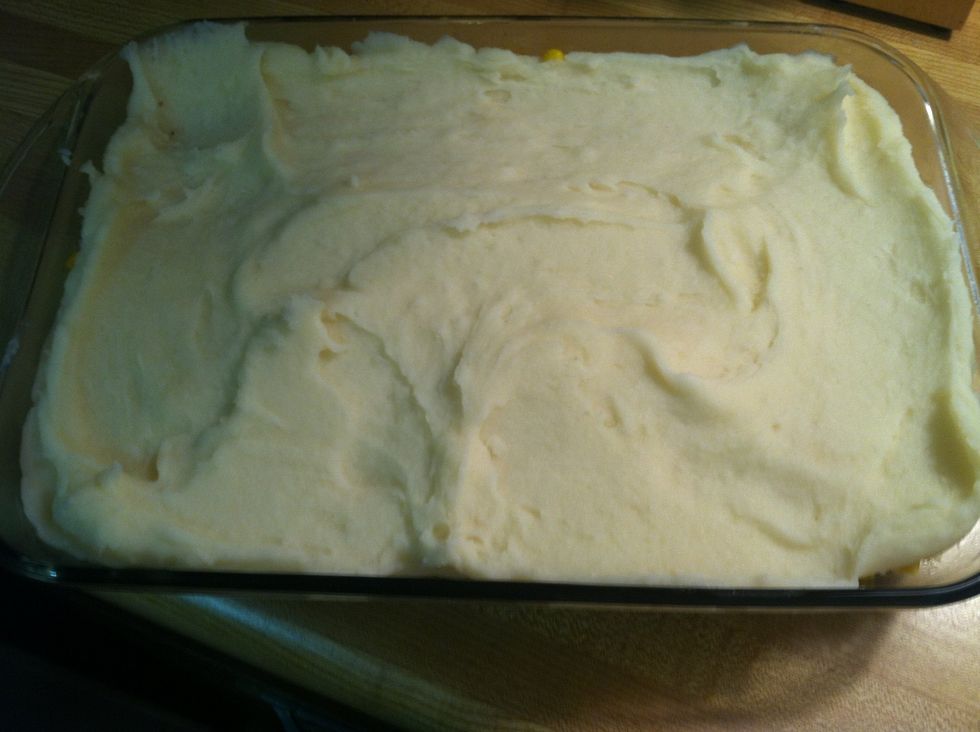 Layer mashed potatoes over corn. Spread evenly with a spatula to reach all corners. (Double tap for larger image)