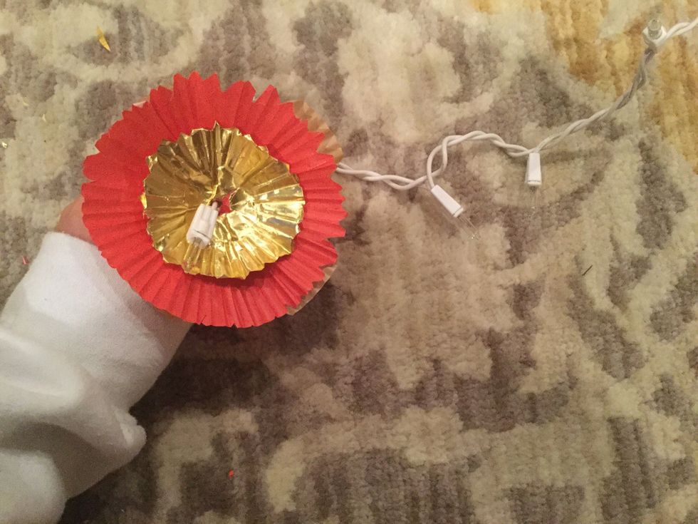 Layer the cupcake liners on top of each light bulb on the string of lights.