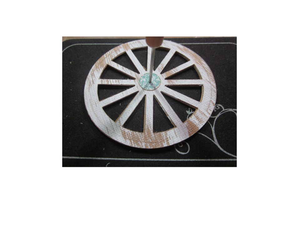 Layer the small circle over the wheel and then using a piercer create a small hole in the center, large enough for a brad to fit through.