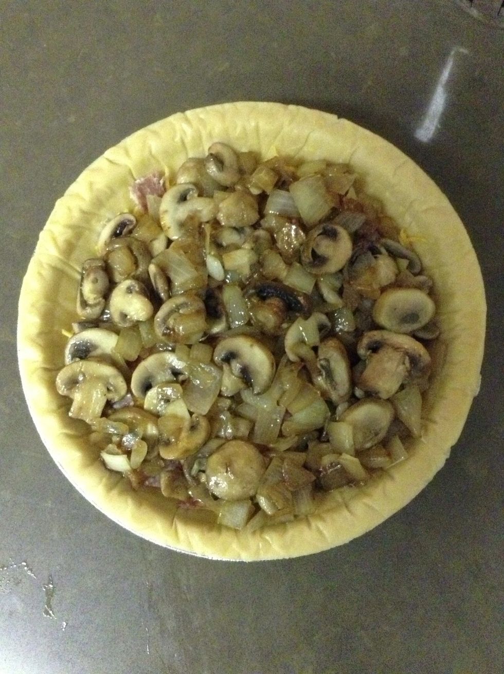 Layer your pie crust with sharp cheddar and add your saut\u00e9ed vegetables