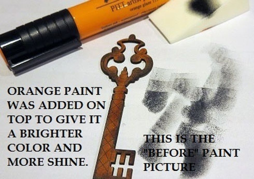 Leaky Shed chipboard key was colored with orange marker, the edges were distressed and then a touch of orange Golden acrylic paint was added for brightness and shine.