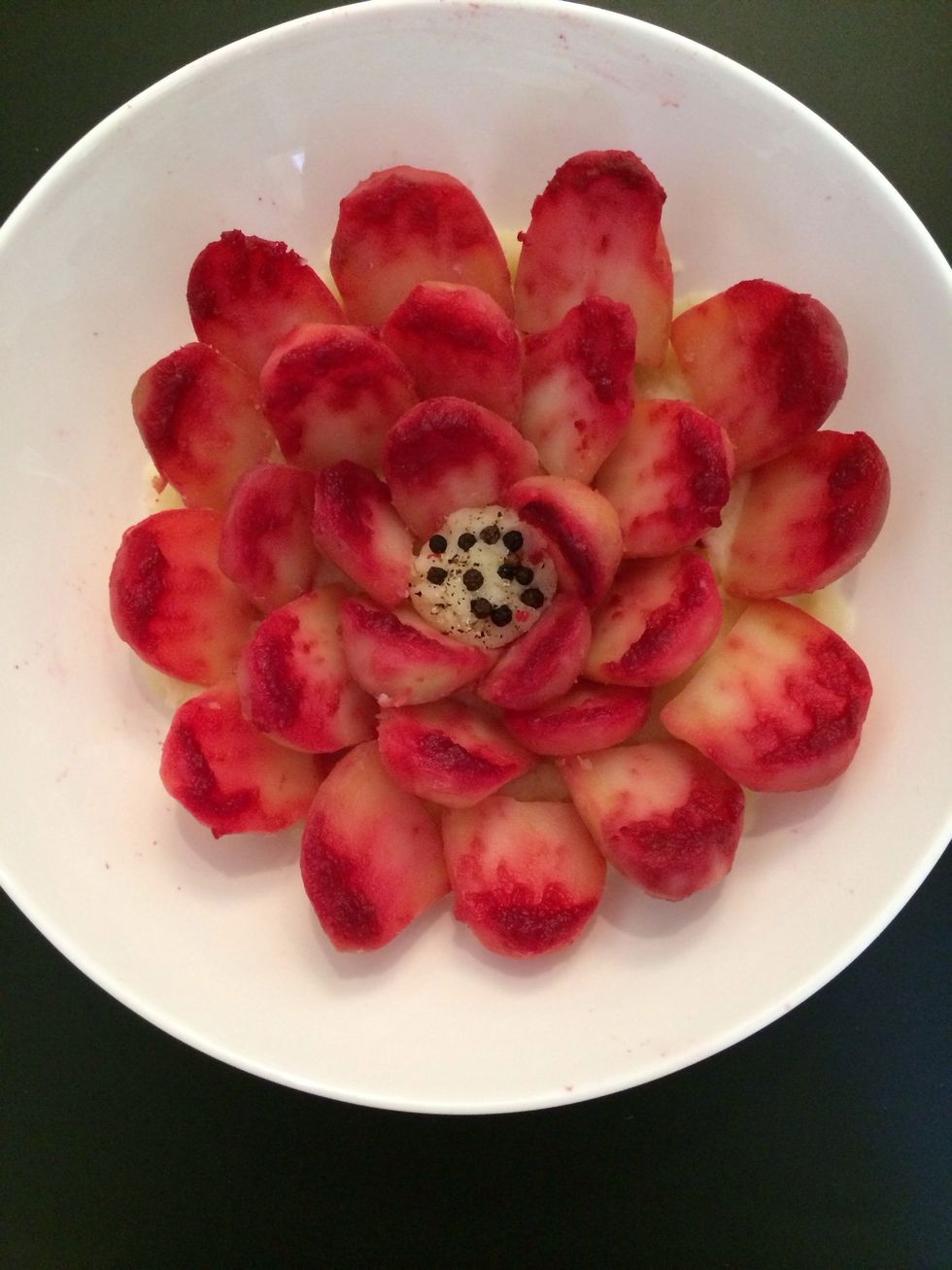 Leave them for a while the red color will spread on the potatoes. Make a thin layer of mashed potatoes and arrange your petals. The middle is just a pit of mashed potatoes decorated wit peppercorns