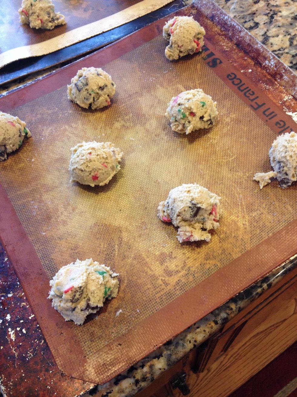 Leave them rounded on the cookie sheet and give them space to cook as they will spread during baking
