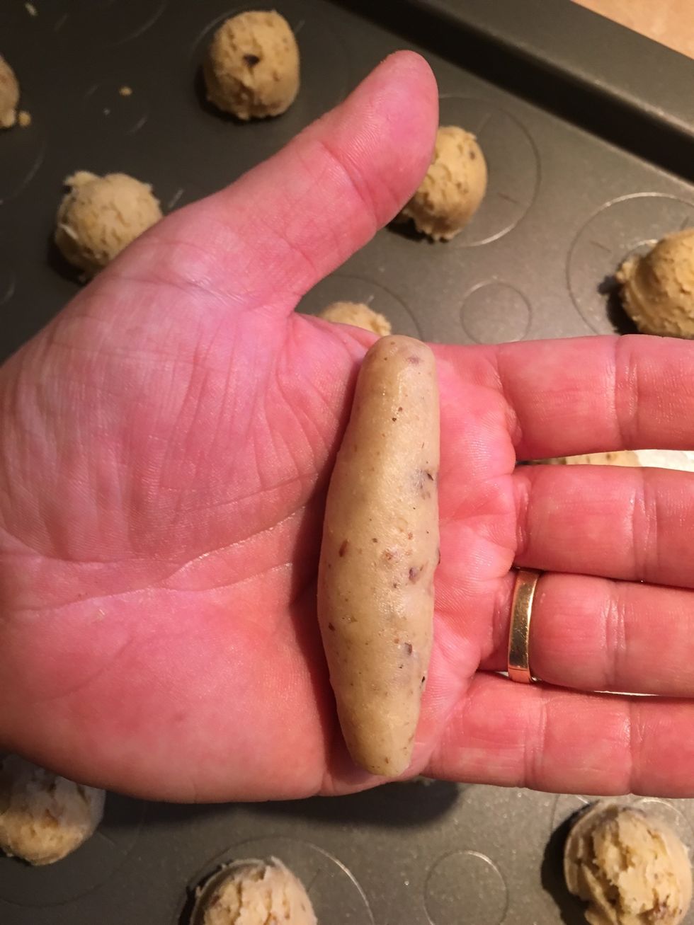 Leaving the dough ball in your hand, again use both palms and roll back and forth to shape into a tube like shape, making sure that the ends are slightly thinner and tapered from the middle.