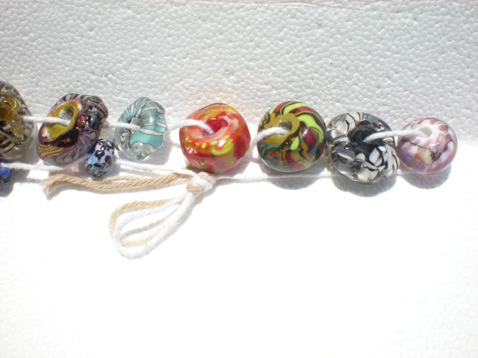 Left side Turquoise & Olive/purple beads have out-of-round holes, which retain bead release (toxic!!!) in pits/pockets. The cord/wire these are threaded onto will erode the bead release onto wearer.