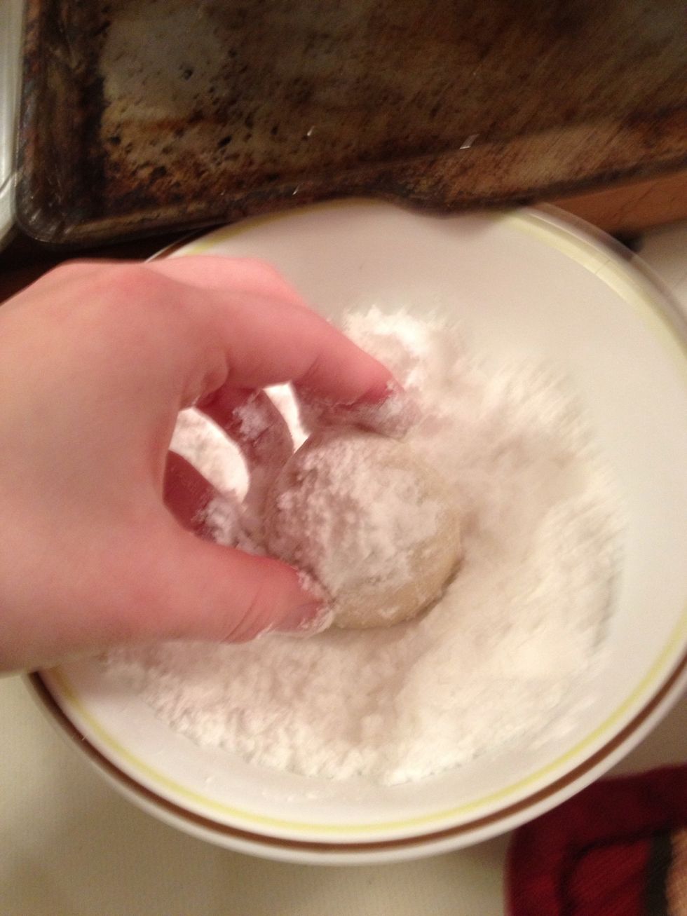 Let cookies cool for about minute or two and then coat in first layer of powdered sugar.