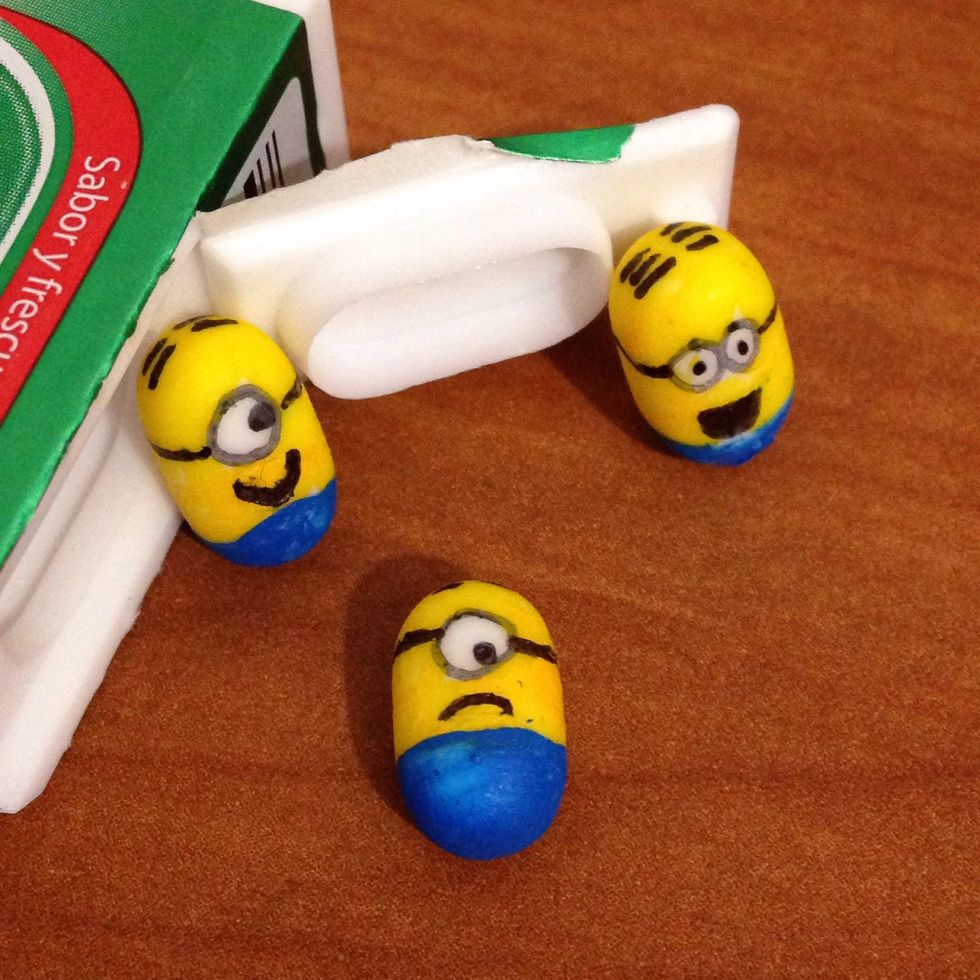 Let it dry and redraw the eyes and add details: hair, mouth and the elastic band of the glasses. Give every minion its own personality.