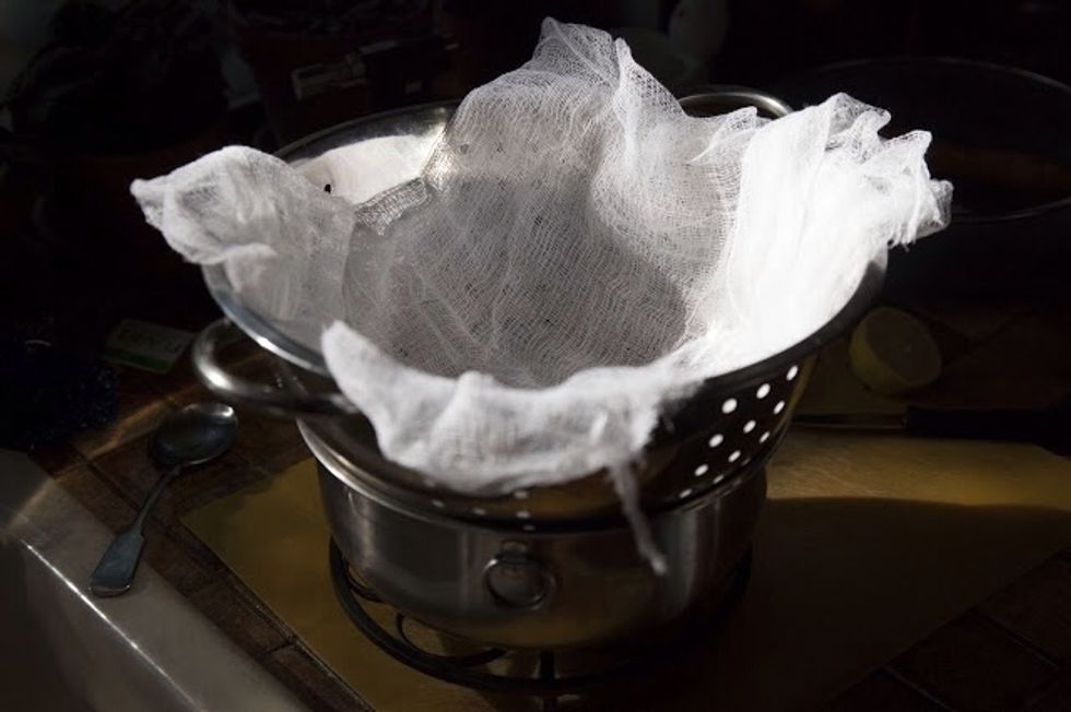 Let it sit off the heat for 5 minutes. Don't touch the cheese while it's sitting there. Line a colander with a couple of layers of cheesecloth and set it on top of a bowl to catch the whey.