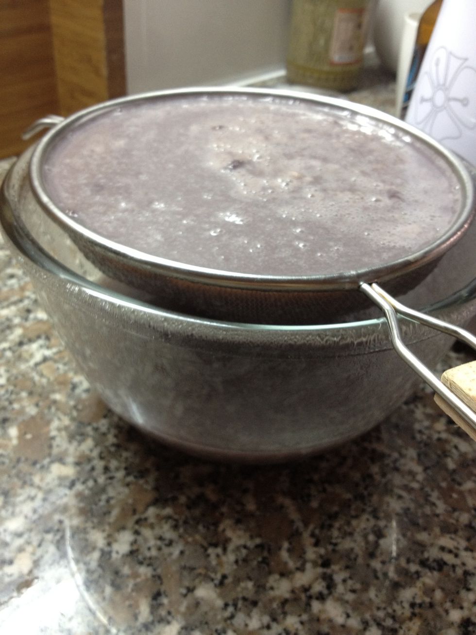 Let it stand. Don't use a spoon since this will force the too small particles through the mesh strainer.