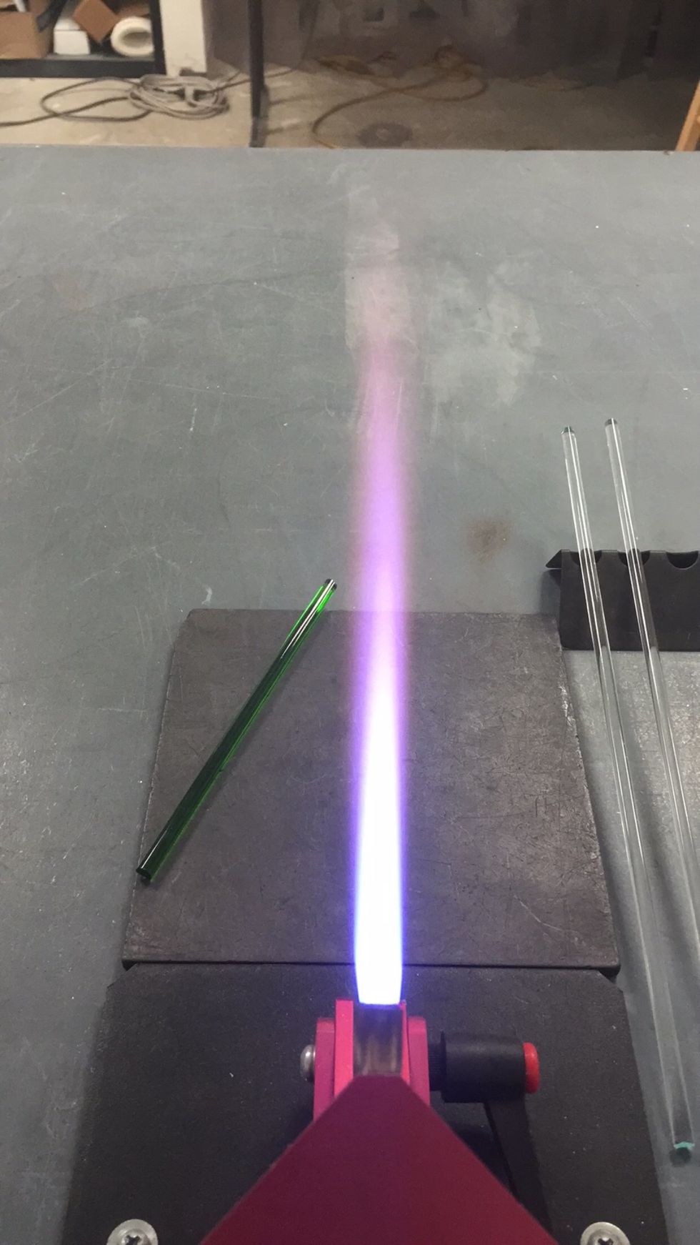 Let's get started! Turn on your torch, set a medium sized, neutral flame. Pick up the half rod of Thallo in one hand and with your other hand pick up one of the clear punties.