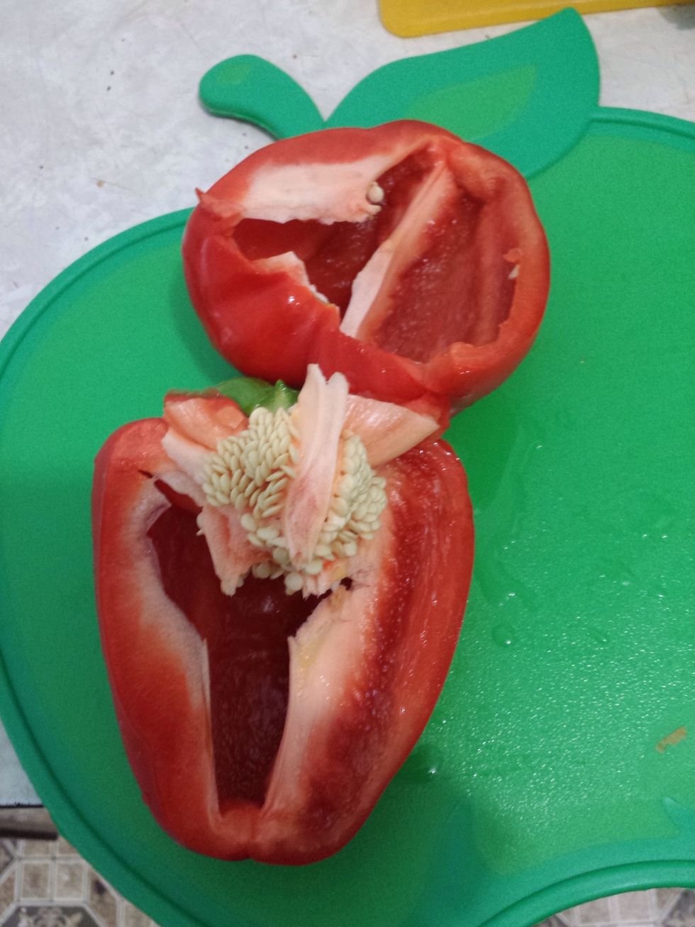 Let's start preparing the capsicums. First cut it in half then take out the seed core and the seeds.