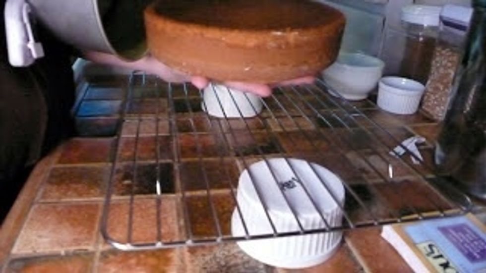 Let the cake pan sit on a wire rack for about 10 minutes to rest, then unmold the cake flipping it onto your hand bottom side up, and place it on a plate.