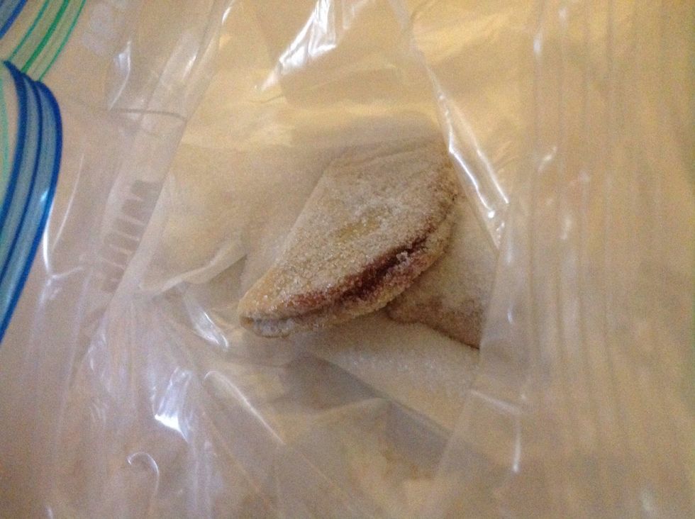 Let the empanadas cool down for 3 minutes. Put the sugar in a plastic bag add three empanadas and shake the bag until the empanadas are completely covered with sugar.