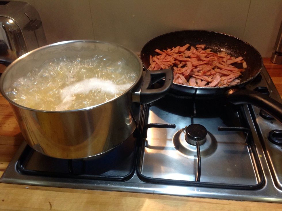 Let the pasta cook and turn the heat down on the bacon