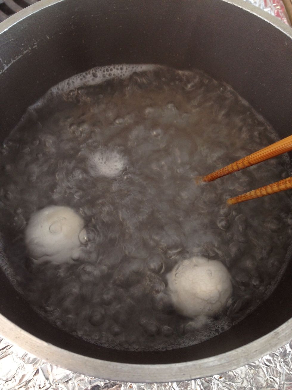 Let the rice ball boil for a while. Lightly roll it around so it doesn't stick to the bottom. When the rice ball start to flout above the water, it's done.