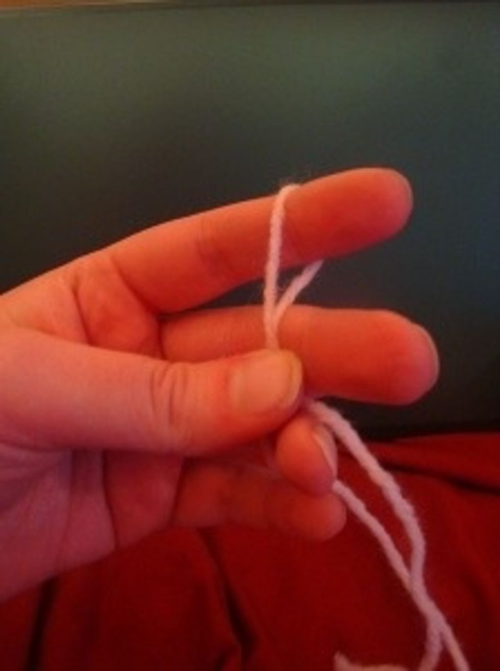 Let the tail of the yarn hang in front of your palm, and loop the yarn loosely around the your index finger on your left hand.