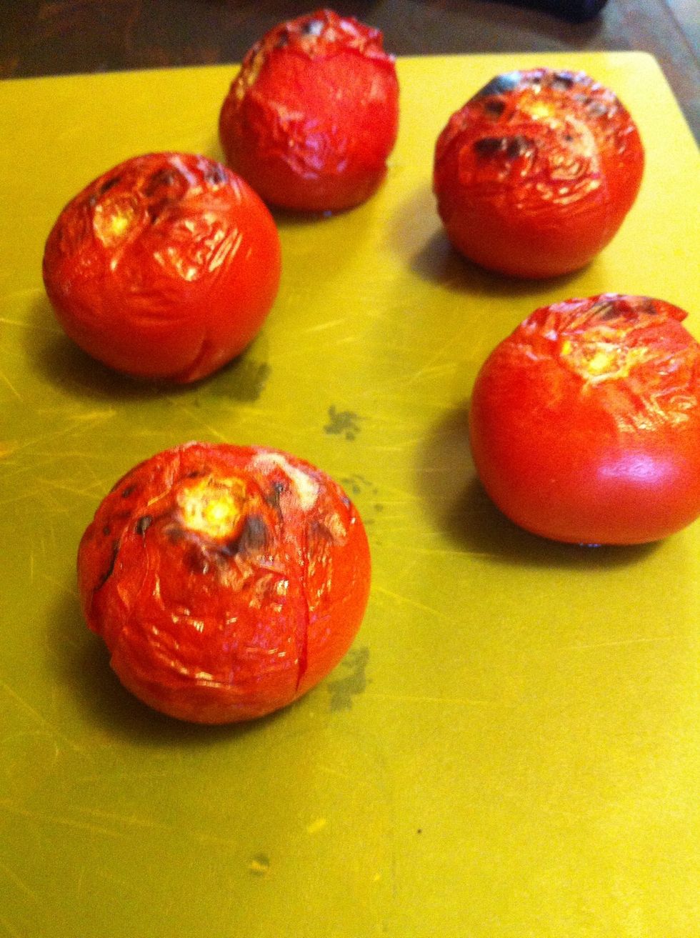 Let them cool! Really! And then pull the skin off the tomatoes, not the jalape\u00f1os. Toss the skin away. Notice I have these on a bendable cutting sheet. That's to save the juices in the next step.