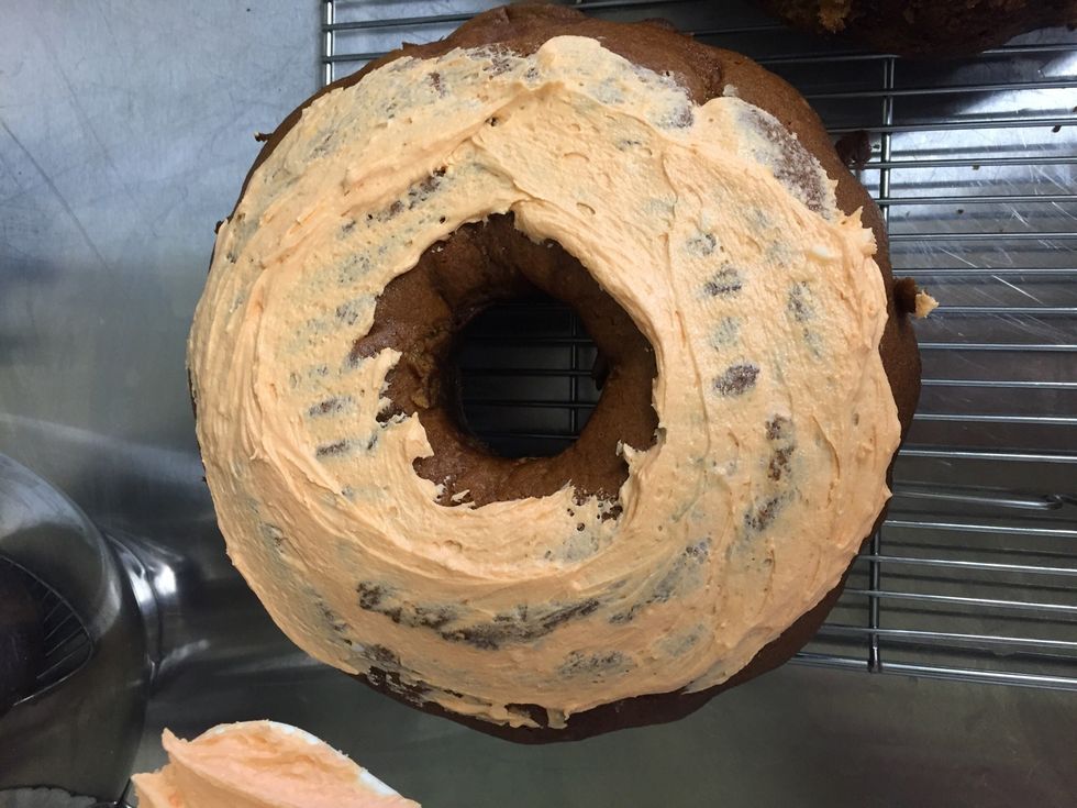 Level off the tops of both bundt cakes so they are aligned when placed on top of each other. Then spread a portion of the icing on one of the flat tops and place them flipped on top of each other