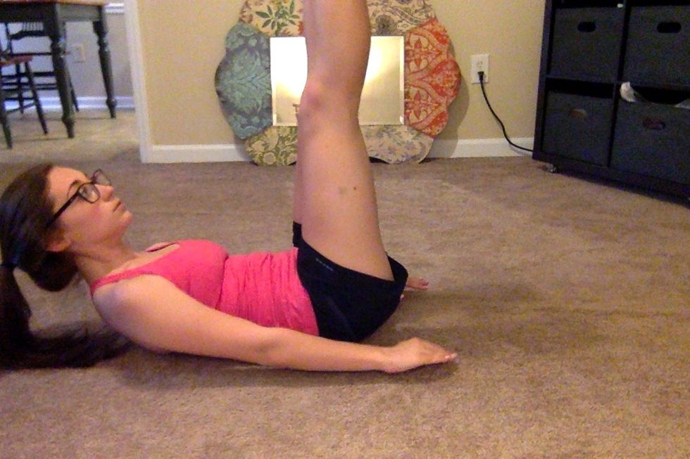 Lift legs straight up, perpendicular to the ground and then lower until they are just a couple inches off the ground. Legs should stay straight the whole time. Thats one rep.