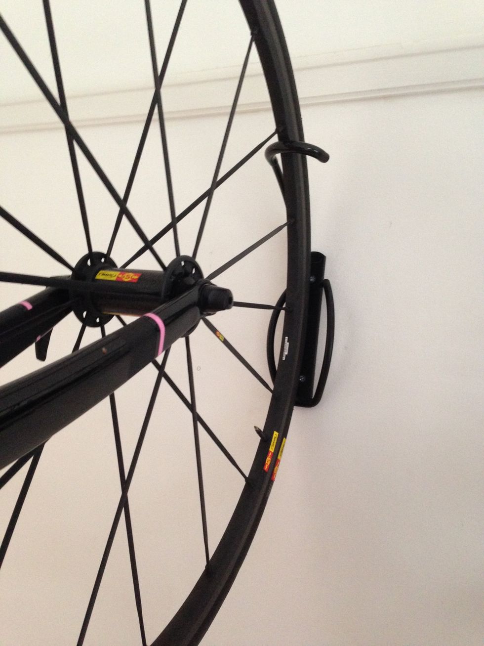 Lift the bike up and hook the rim of the tyre into the rack