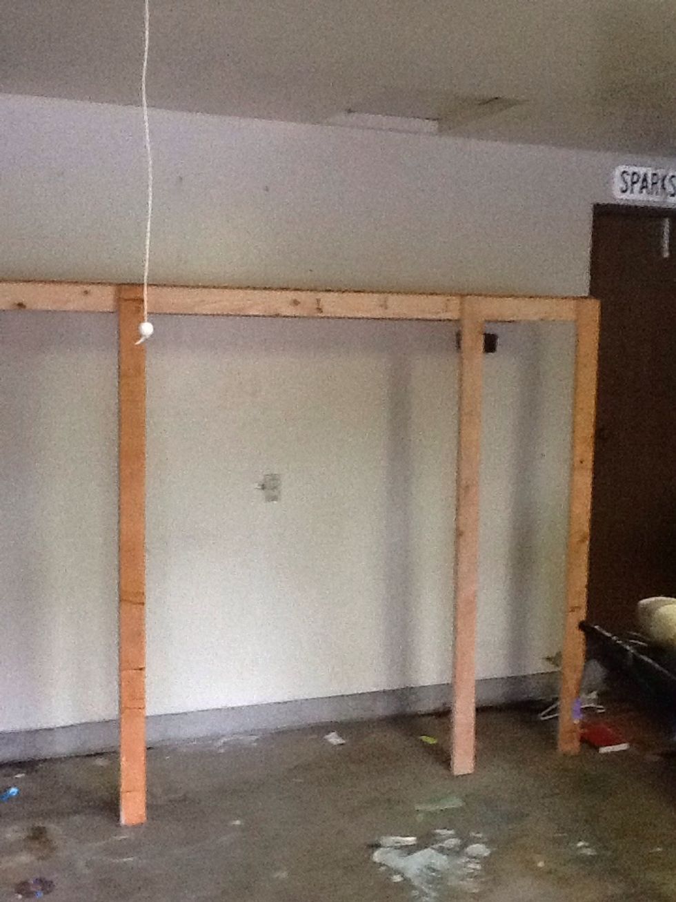 Lift the frame up and rest the top shelf on the stud you placed on the wall in the first steps. It should sit well, you can adjust the legs to make sure you have a flush fit.