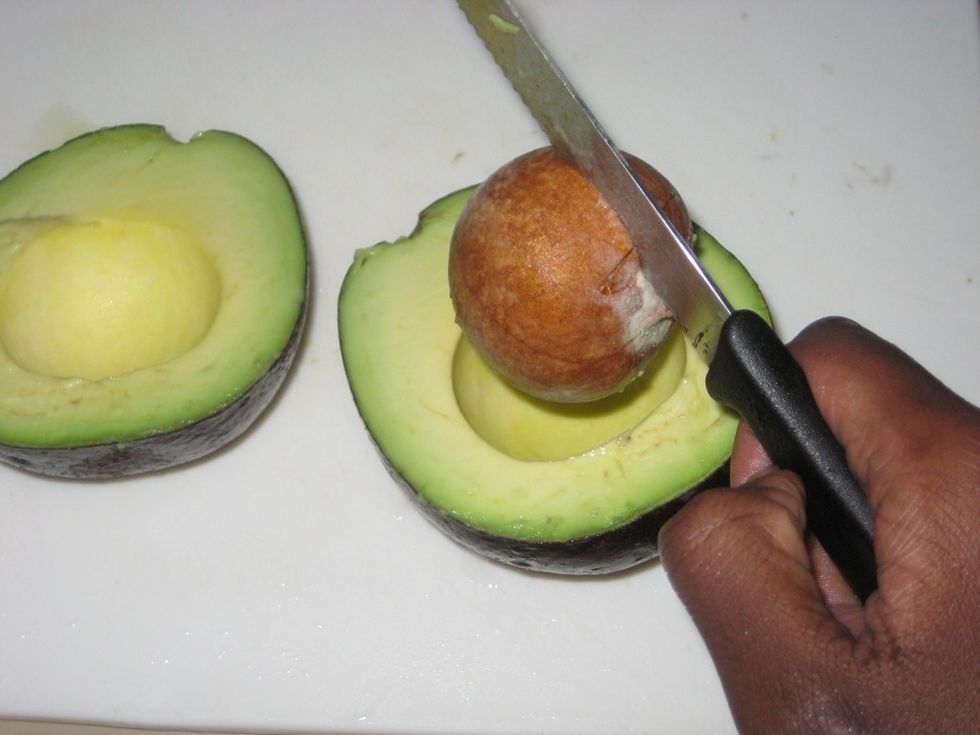 Lift the seed out of the avocado and discard.