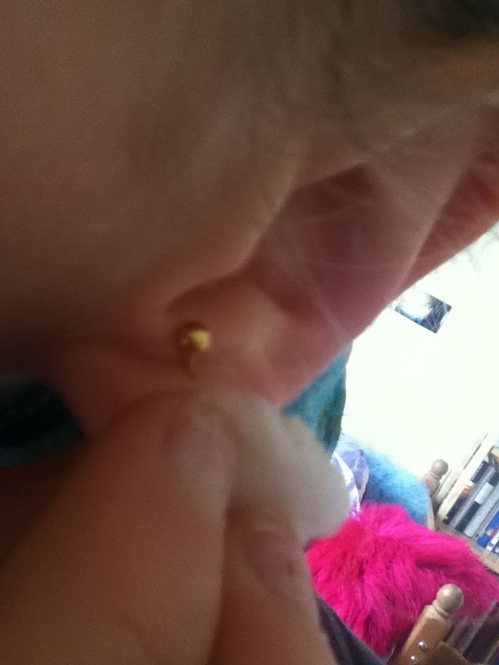 Lift up earring and try to get the wash in hole