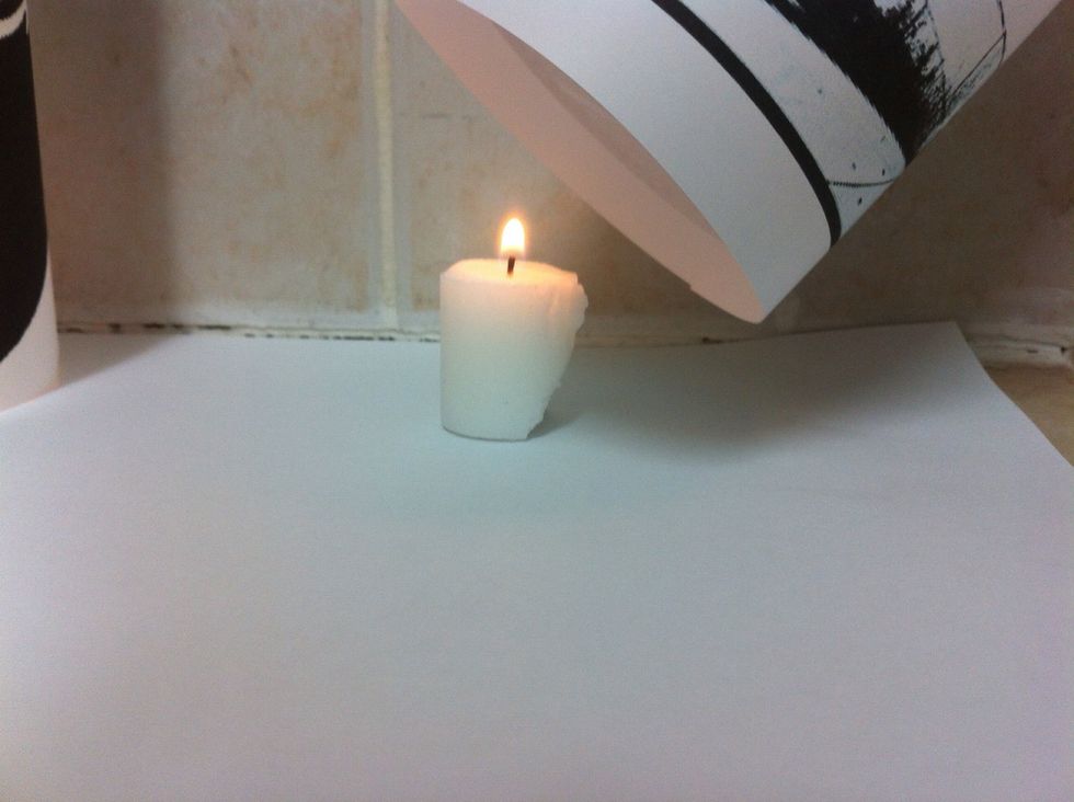 Light a candle and cover it with the paper roll