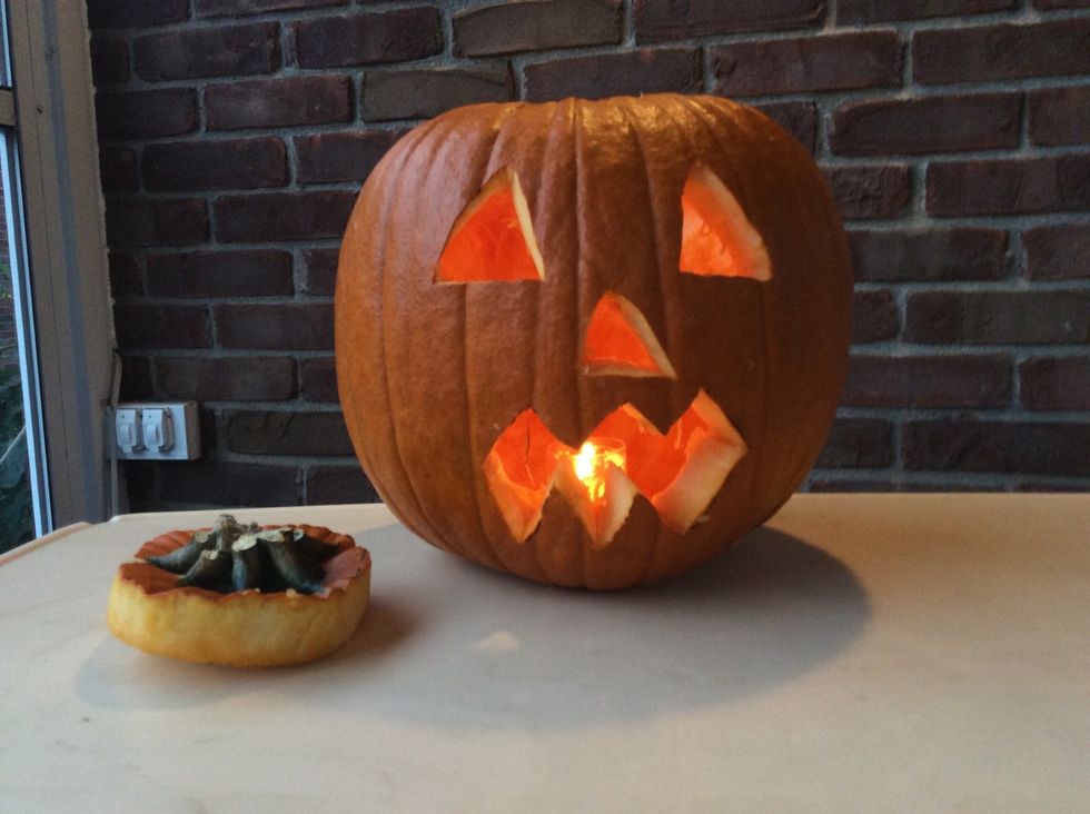 Light candle with the matches and place it in the pumpkin.