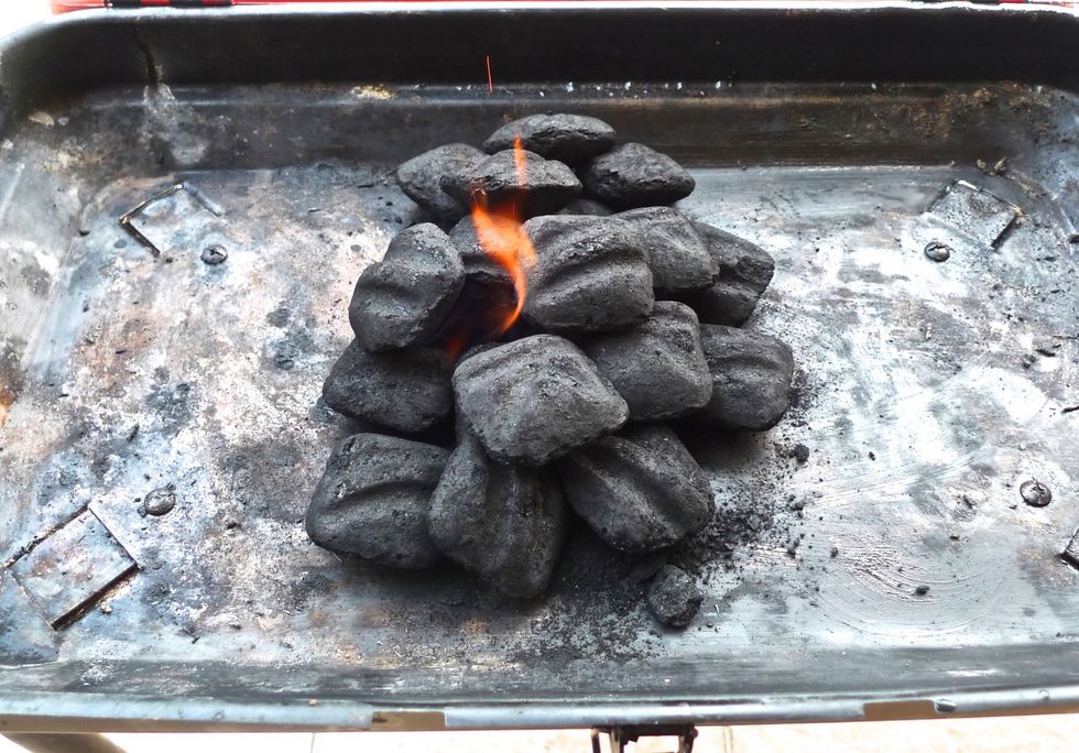 Light the charcoal briquettes.