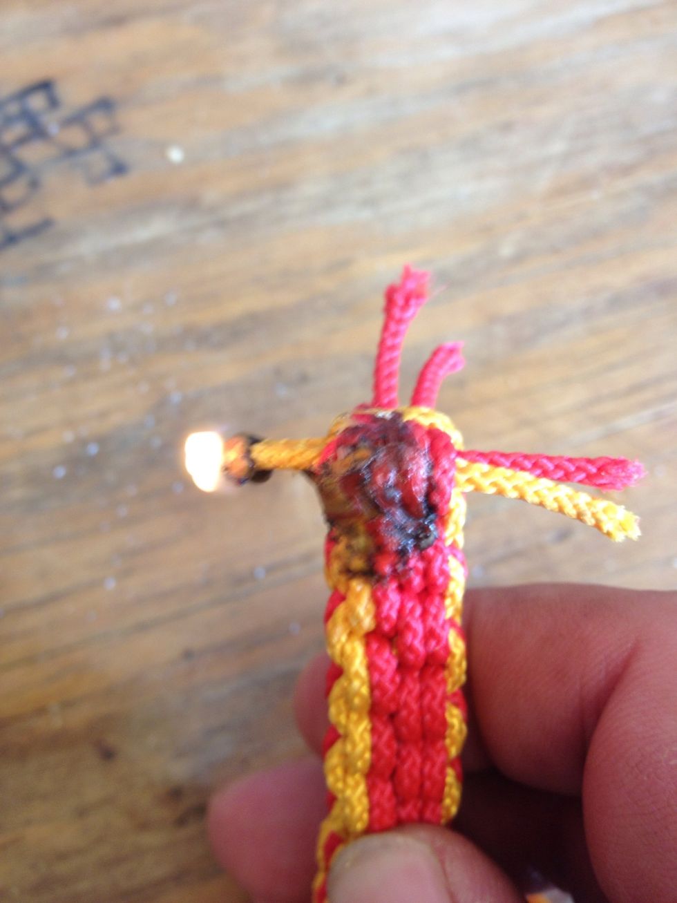 Light the excess with a lighter and smash the melted nylon on a piece of wood or metal or use your fingers with leather gloves