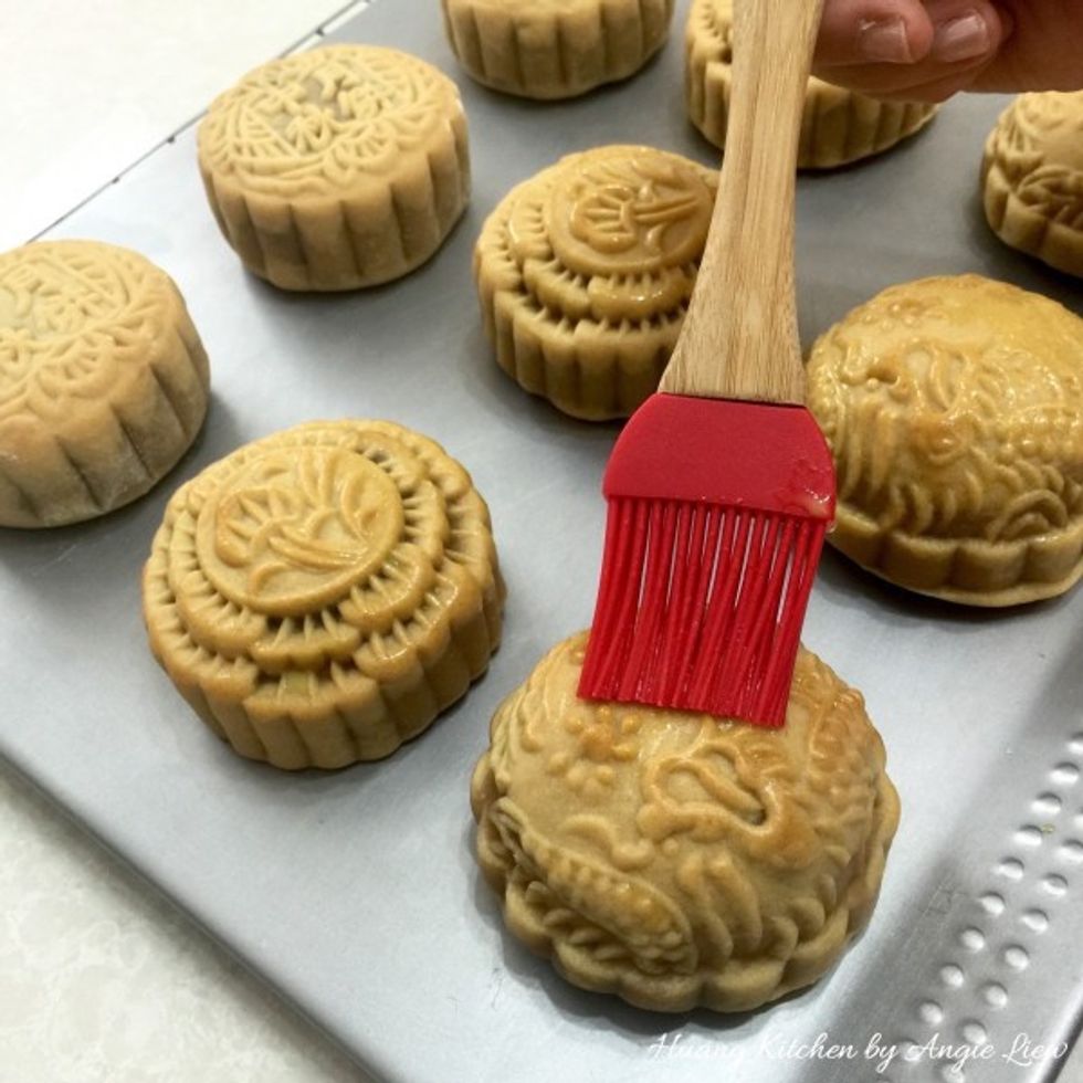 Lightly brush as thoroughly as possible the top of mooncakes with egg wash.