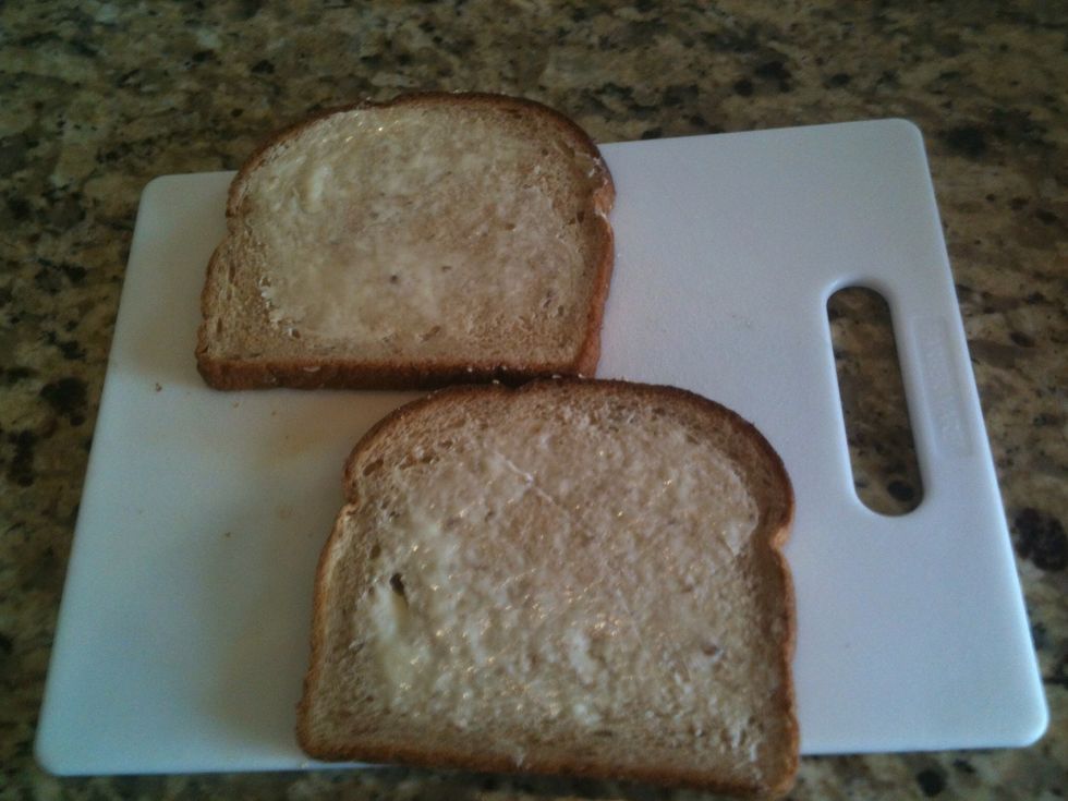 Lightly butter one side of 2 slices of bread.