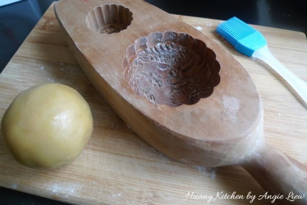 Lightly floured a traditional wooden mooncake mould.