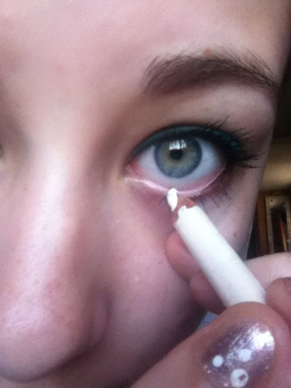 Lightly line the inner corners of your lower lashline with a white kohl pencil.