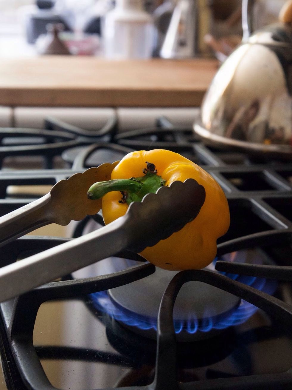 Lightly rub the peppers with vegetable oil and either place them on a baking sheet under the broiler, or on the grill or as I did on a low gas flame on top of the oven.