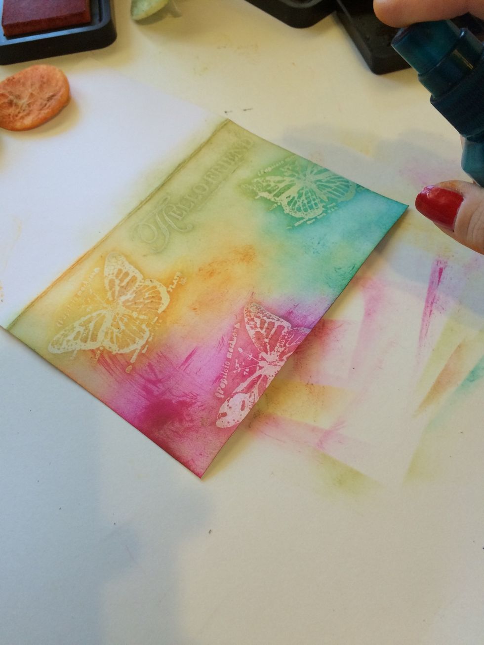 Lightly spray your card. The purpose is 2 fold (1) to blend the edges of your colors & (2) to remove the ink from on top of your stamped images.