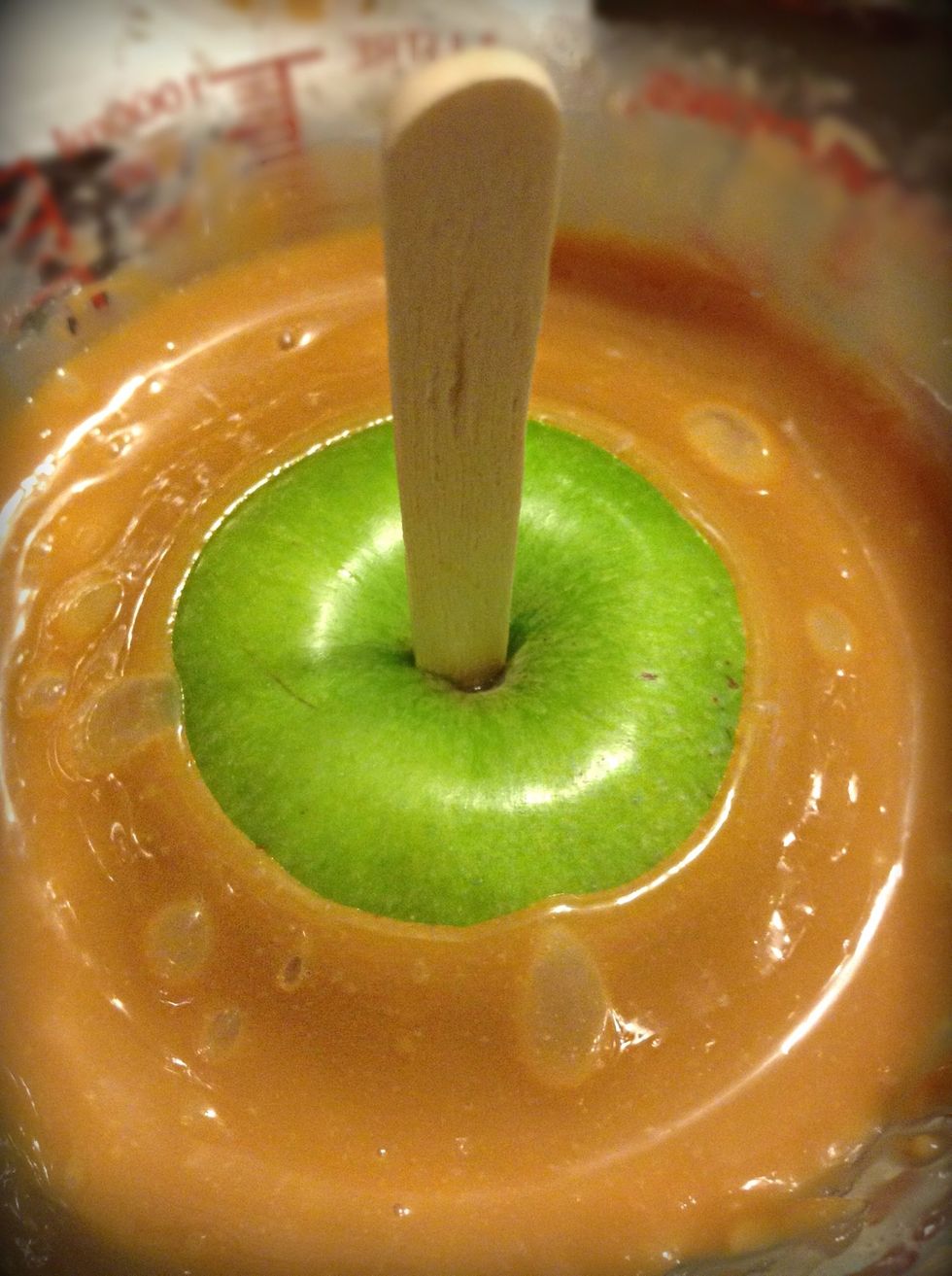 Like so, lift your caramel apple up and allow any excess caramel to drip back into the measuring cup. With a knife scrap the bottom of the apples to get off any MORE of the excess caramel.