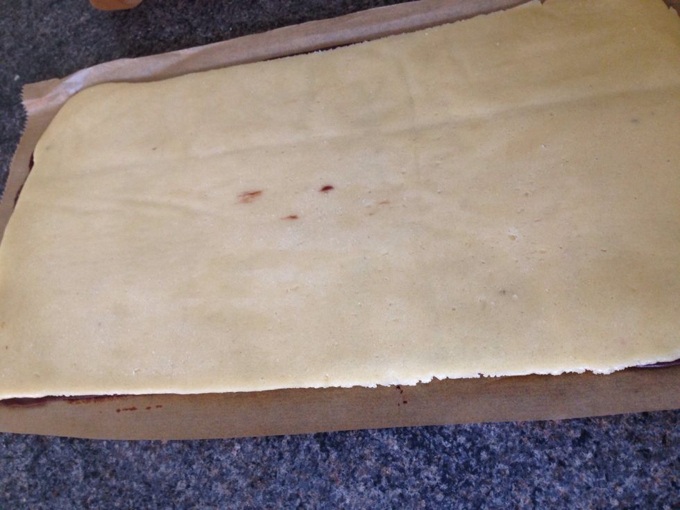 Like this. Roll tightly along the long side. Use the paper to help you along. If the outer dough cracks, let it soften for a few minutes and roll.