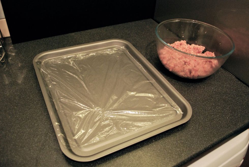 Line a baking tray with cling film. This is where you will put the formed meatballs