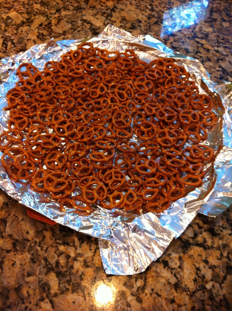 Line a large sheet (I used a pizza sheet) with aluminum foil. Then spread out about half a bag of tiny twist pretzels.