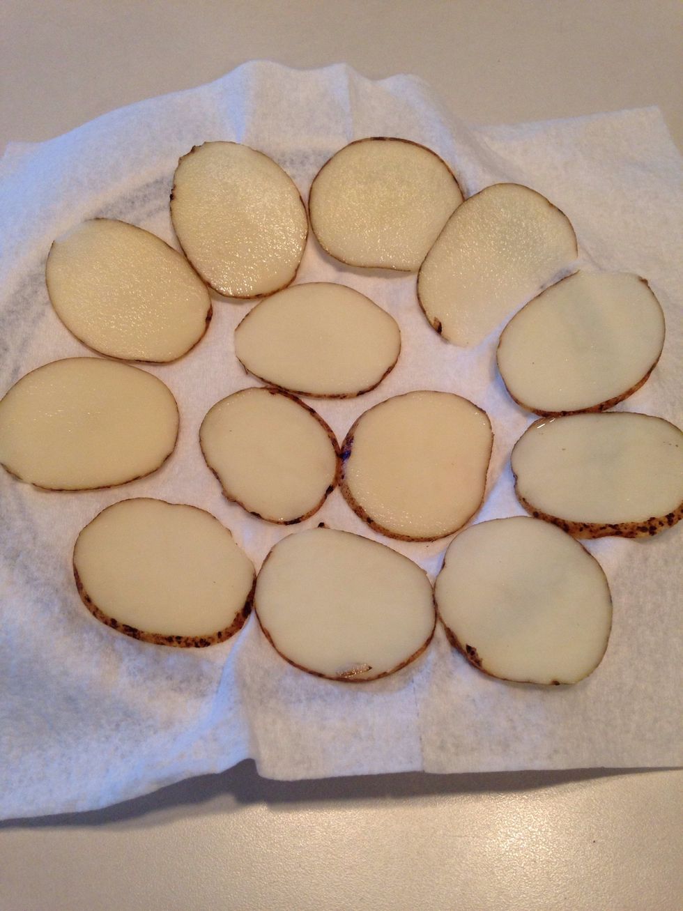Line a plate with a paper towel and place a flat layer of potatoes on top.