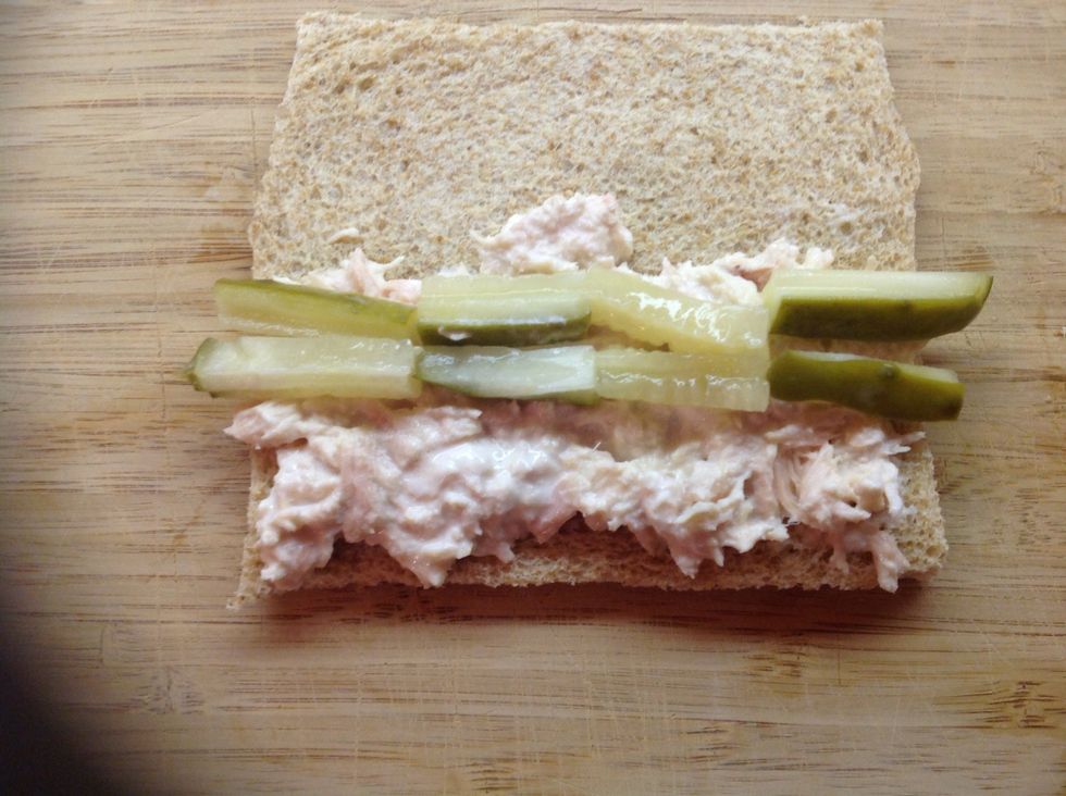 Line about half of the pickles up at the edge of your tuna. Let them stick out over the edge of the bread a little.