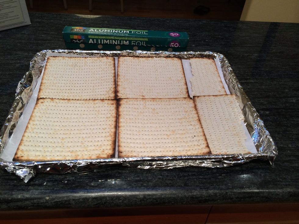 Line the cookie sheet with matzohs, breaking the pieces so that they cover evenly.