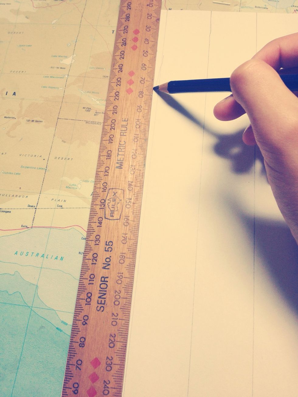 Line the edge of the ruler with the edge of the paper and draw a line down the edge.