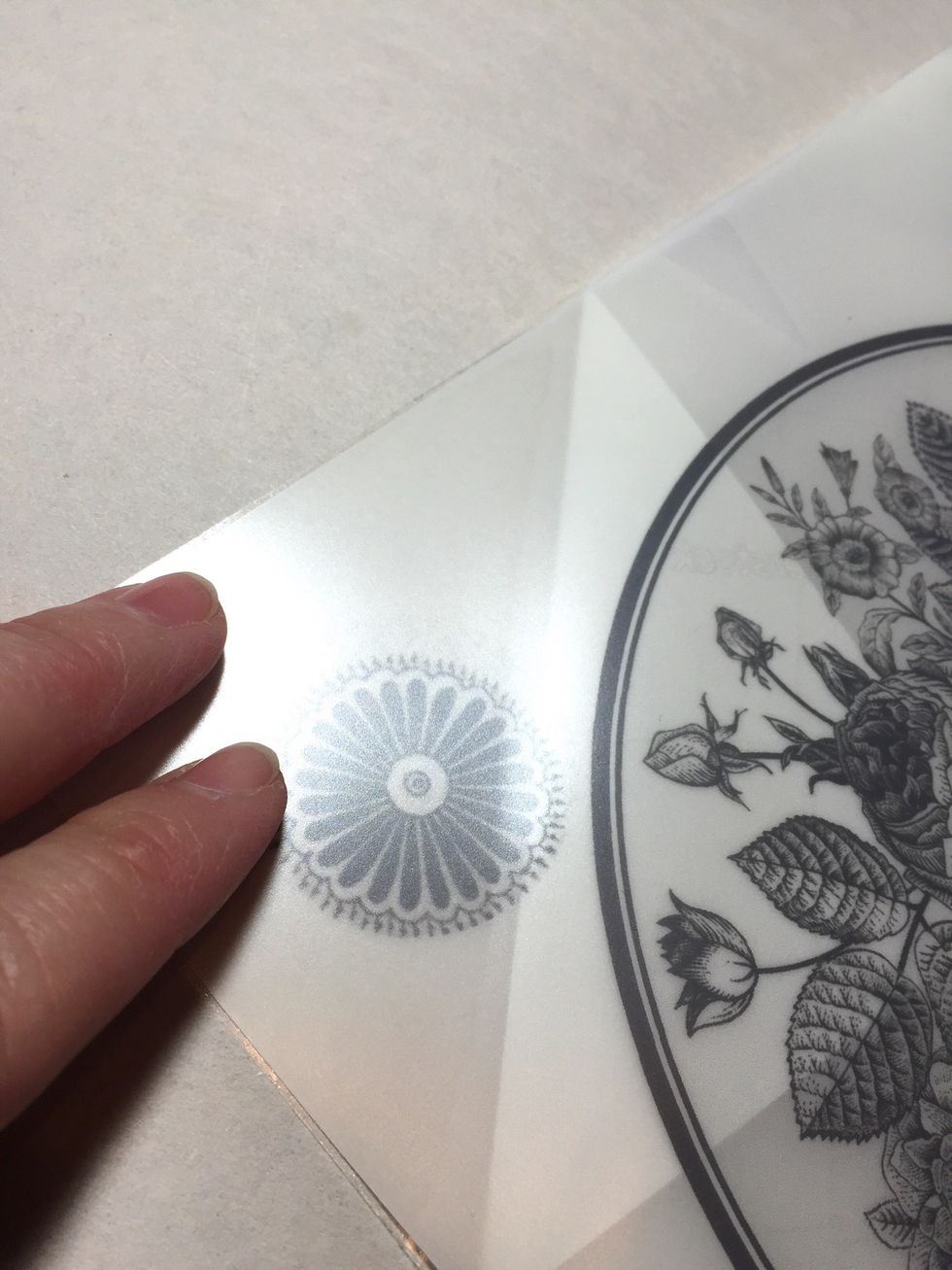 line up a corner of the transfer film to the corner of the adhesive sheet and press to adhere just the corner.