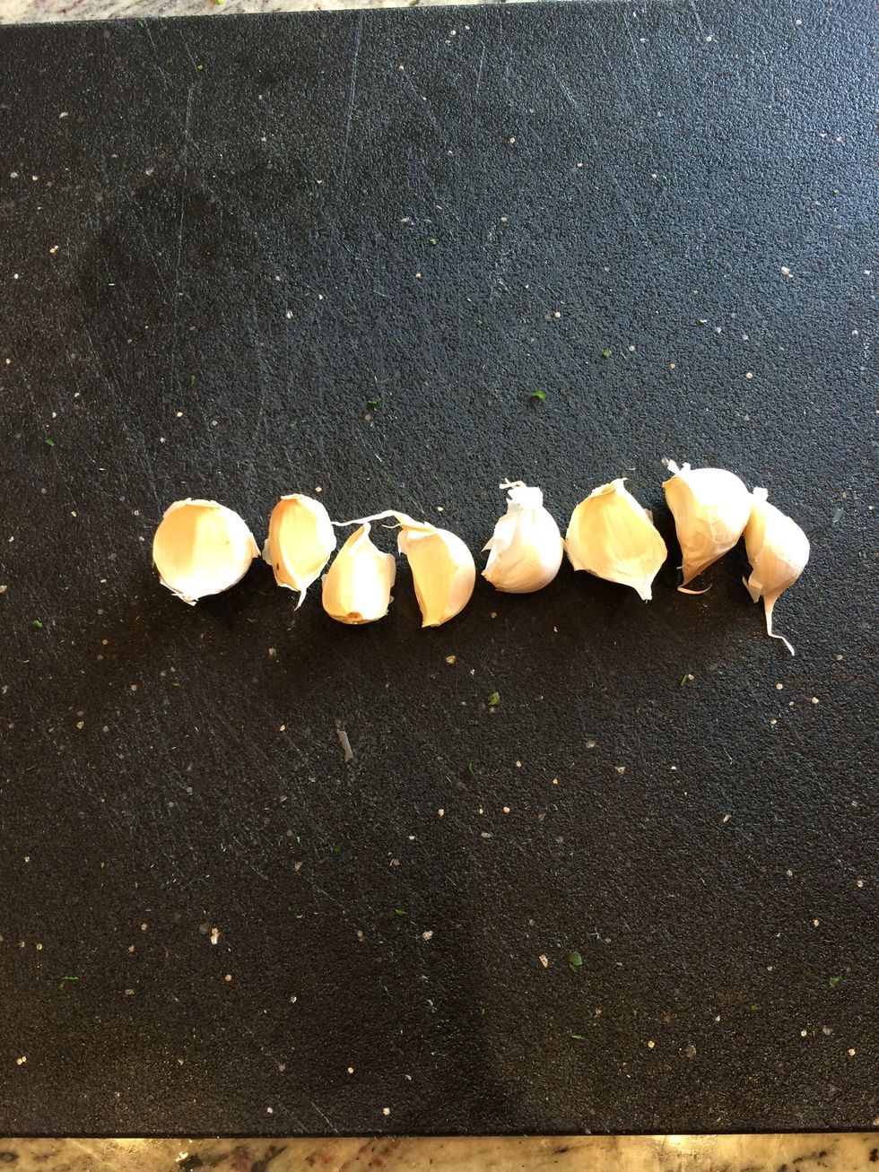 Line up garlic cloves on cutting board