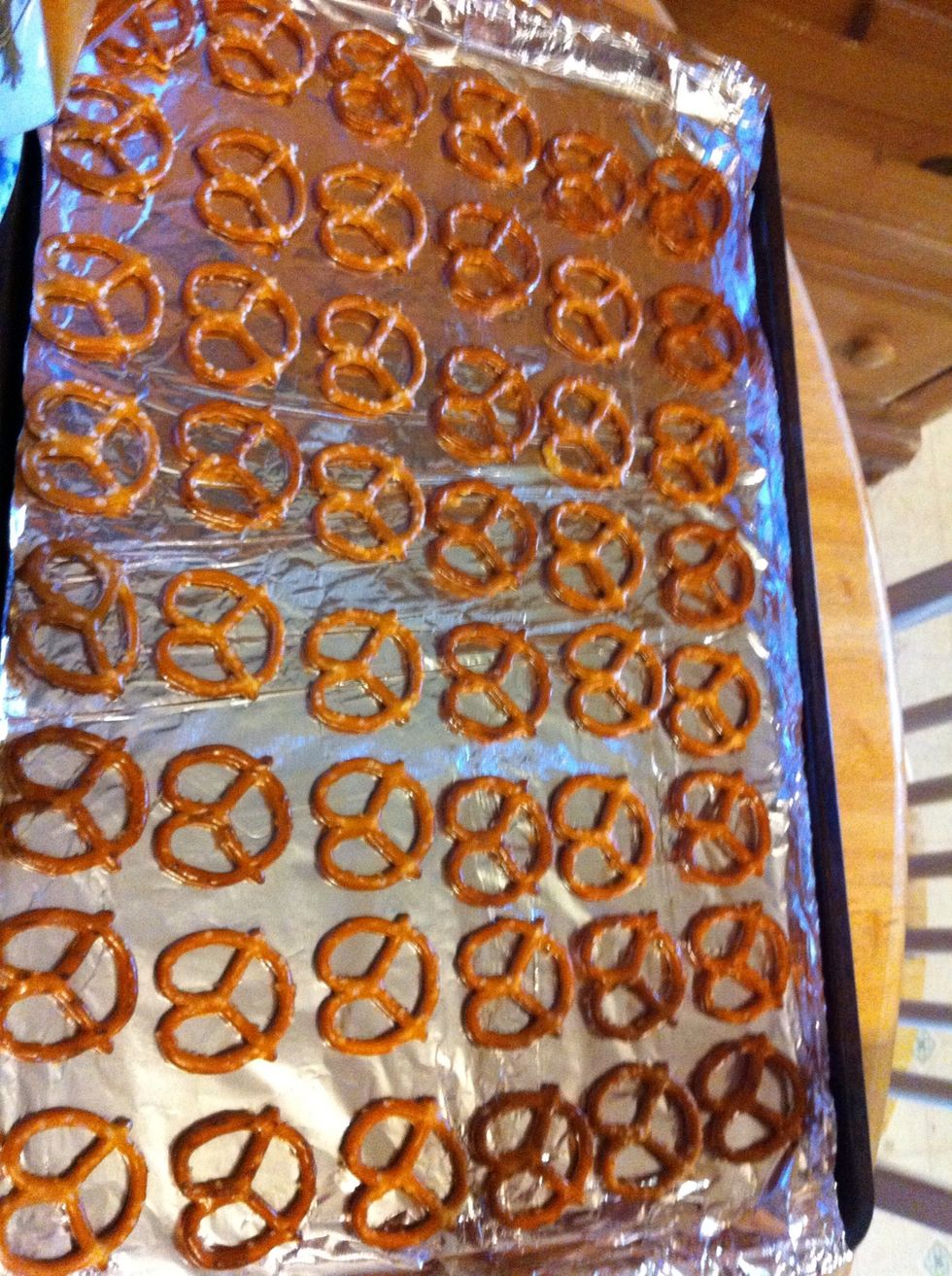 Line up pretzels on covered cookie sheet.