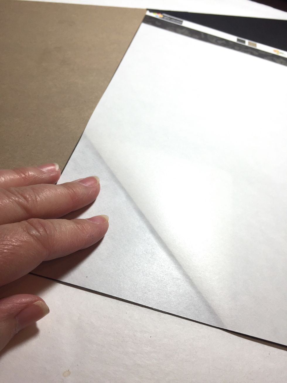 line up the corner of the adhesive with a corner of the paper. and work as before, pulling on corner of backing to expose the adhesive and pressing and smoothing adhesive to paper as you go.
