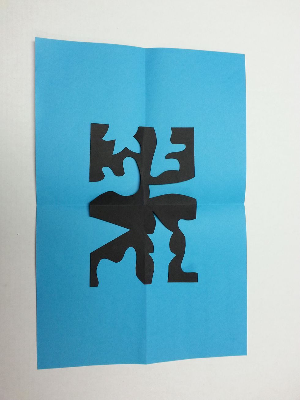 Line up the folds on the black rectangle with the folds on the colored paper. (This will help you center the black rectangle on the colored paper.)